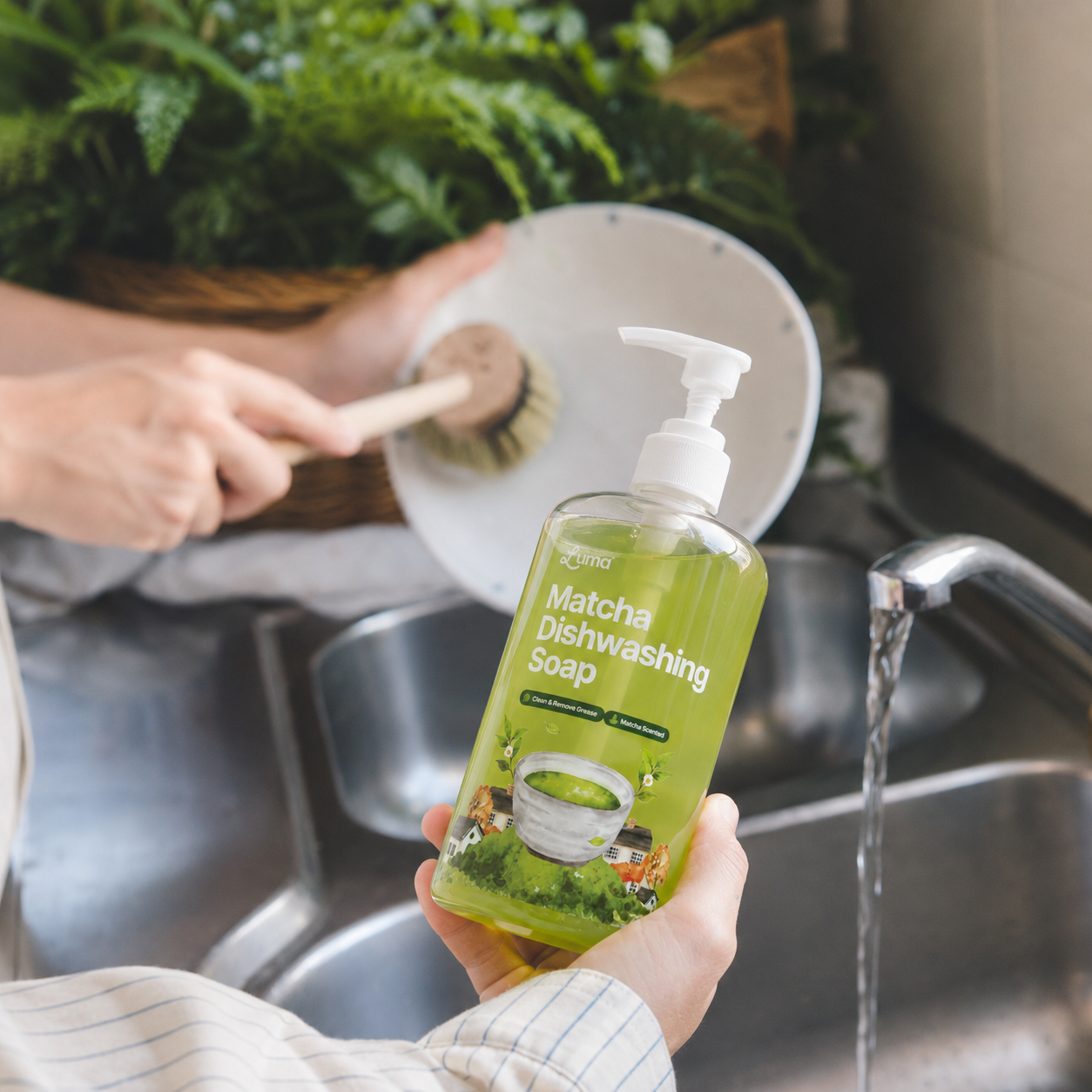 Hands washing dishes at the kitchen sink with Luma Matcha Dishwashing Soap